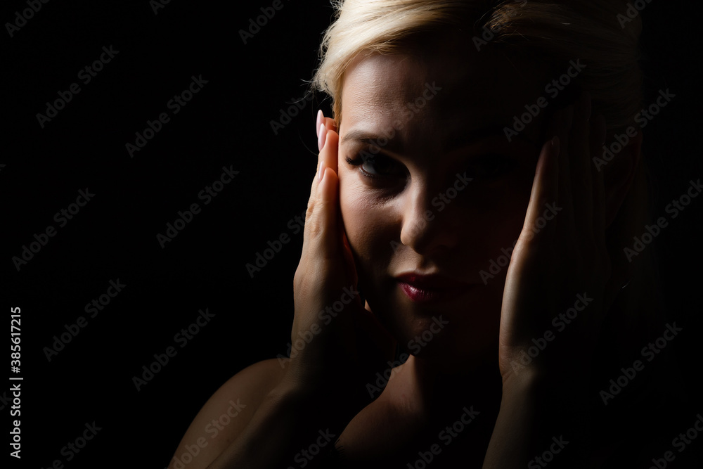 Young beautiful blond glamorous woman in black over dark background Young beautiful blond glamorous woman in black over dark background