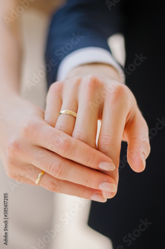 Wedding rings on the fingers of a young couple close up