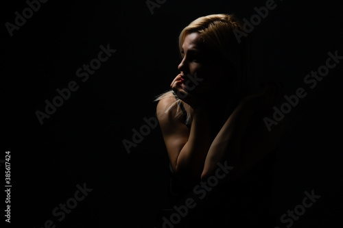 Fényképezés Young beautiful blond glamorous woman in black over dark background