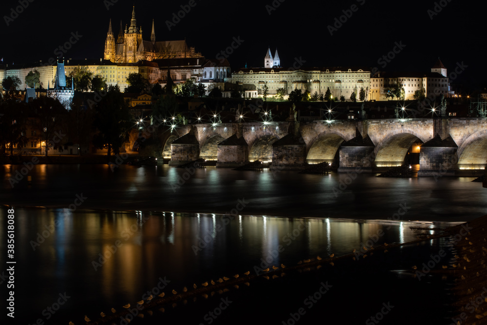 
panoramic view of Prague Castle St. Vitus Cathedral and Charles Bridge in the center of Prague at night and lights from street lights