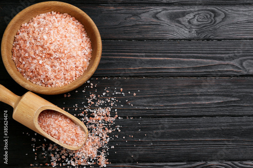 Pink himalayan salt on wooden table, flat lay. Space for text photo