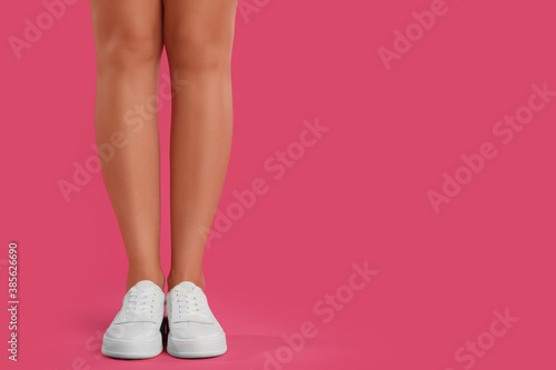Woman wearing shoes on pink background, closeup. Space for text