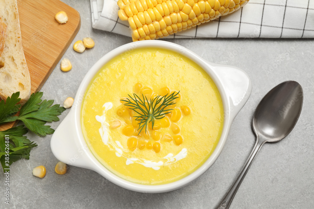 Delicious creamy corn soup served on grey table, flat lay Delicious creamy corn soup served on grey table, flat lay