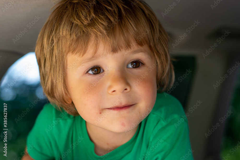 portrait of a child in a car wearing green shirt portrait of a child in a car wearing green shirt