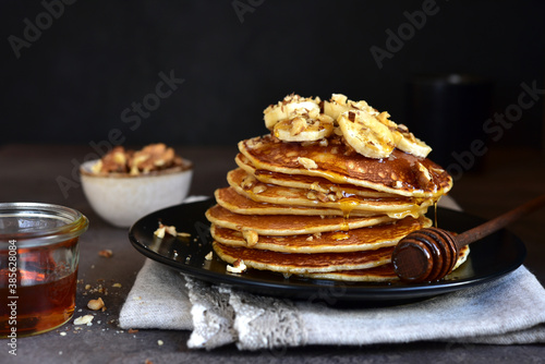 Hot delicious pancakes with honey or maple syrup.