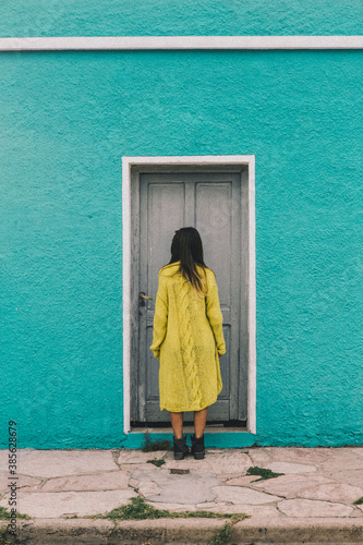 artistic - woman in front of door - blue background
