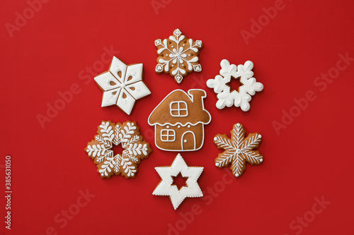 Different Christmas gingerbread cookies on red background, flat lay photo