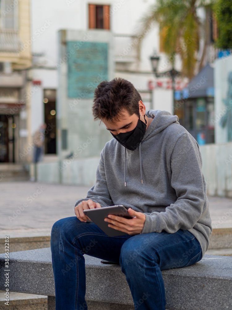Hombre de negocios trabajando con su tablet  en la calle sentado