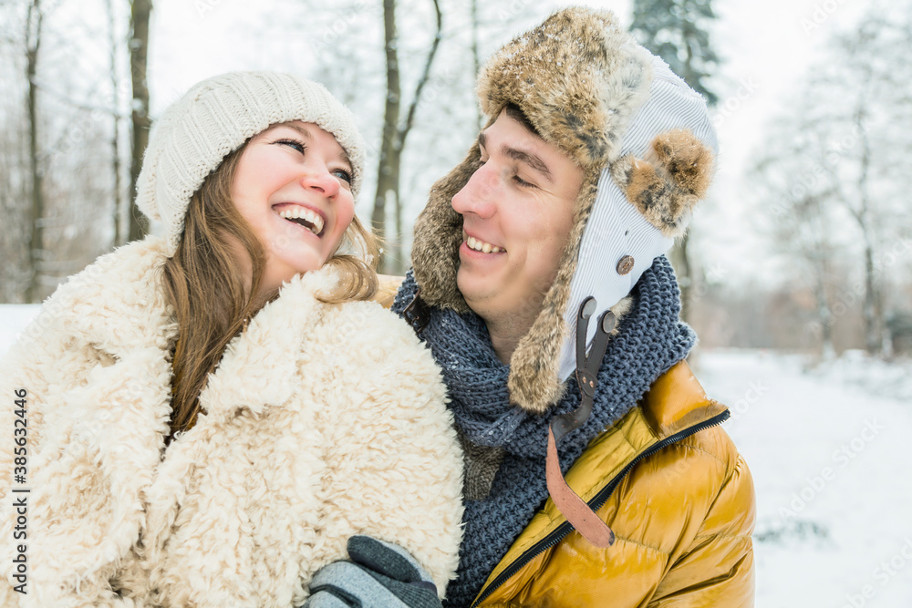 happy loving couple walking in snowy winter forest, spending christmas vacation together. Outdoor seasonal activities happy loving couple walking in snowy winter forest, spending christmas vacation together. Outdoor seasonal activities