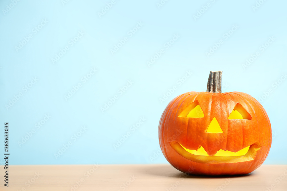 Scary jack o'lantern pumpkin on light blue background, space for text. Halloween decor Scary jack o'lantern pumpkin on light blue background, space for text. Halloween decor