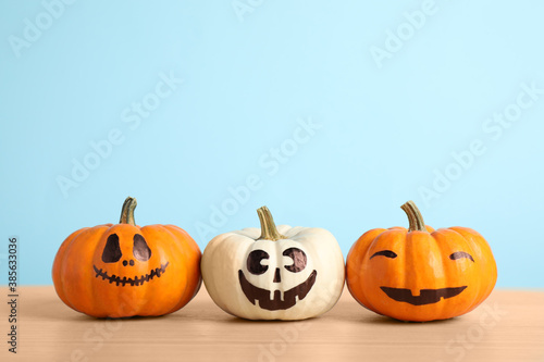 Pumpkins with scary faces on light blue background, space for text. Halloween decor © New Africa
