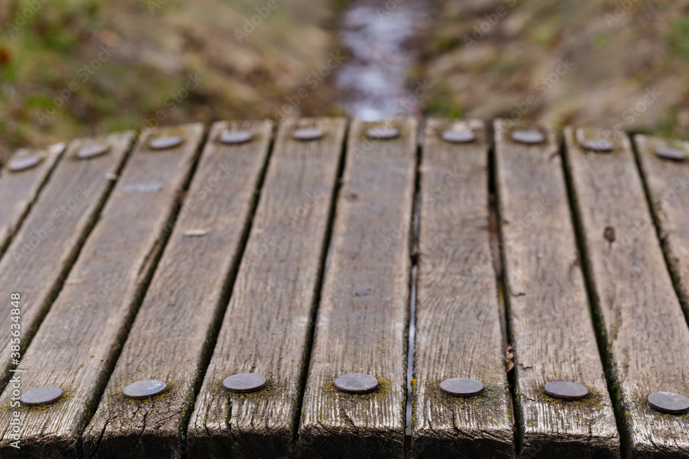 Old wooden boards of a bridge with round iron rivets. Old wooden boards of a bridge with round iron rivets.