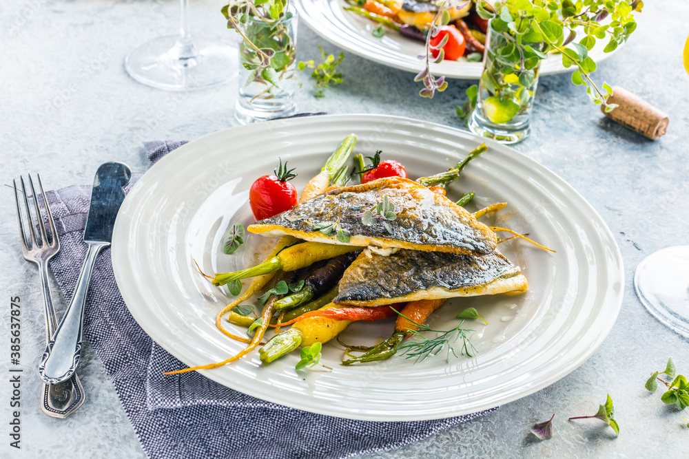  sea fish with rainbow carrot and wine     glasses on bright table. gourmet dissh