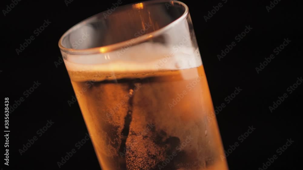 Cold Light Beer in Glass, Spinning Close Up on Black Background Cold Light Beer in Glass, Spinning Close Up on Black Background