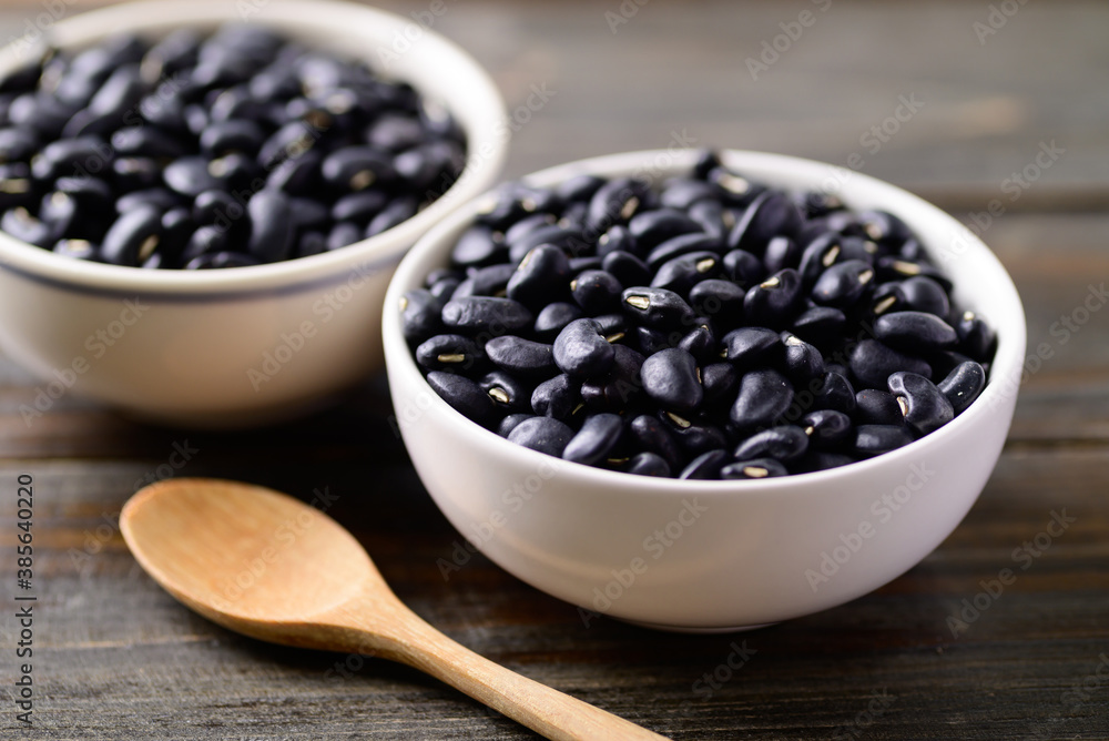 Black kidney beans in a bowl and spoon on wooden background Black kidney beans in a bowl and spoon on wooden background