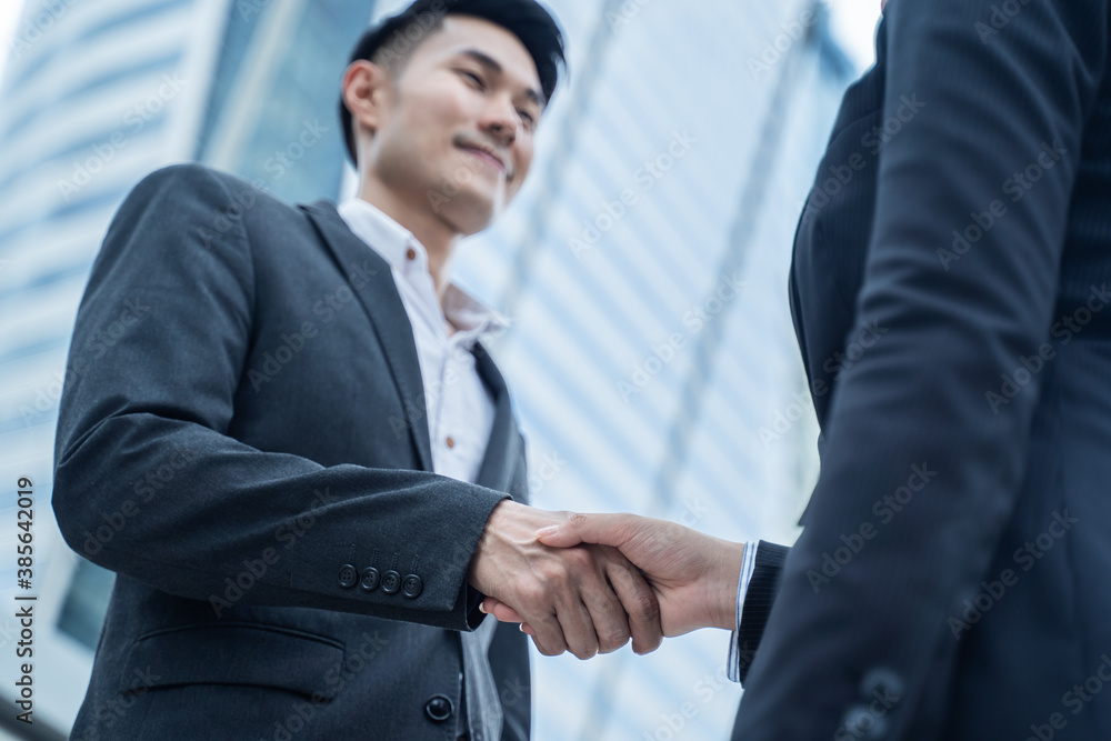 Asian businessmen make handshake in the city with building background. Asian businessmen make handshake in the city with building background.
