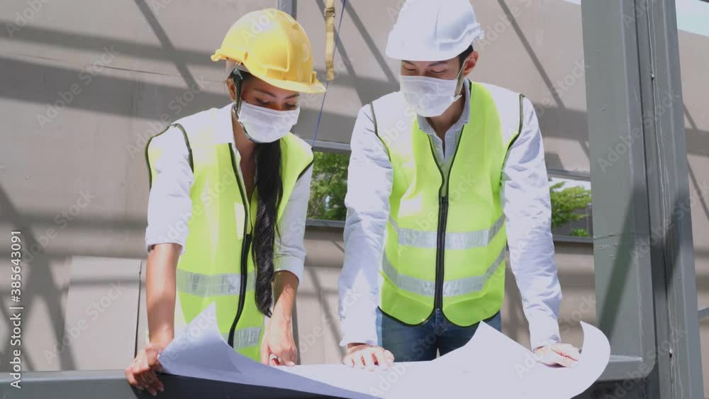 Asian young engineer man explaining job on drawing to female worker. Asian young engineer man explaining job on drawing to female worker.