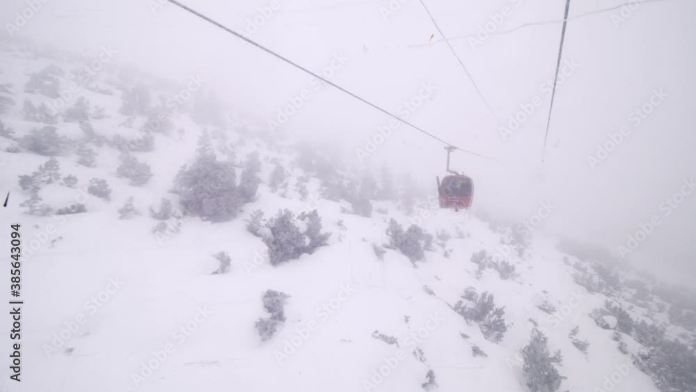 Gondola ski lift in Borovets, Bulgaria. Cabins on a steel cable on a foggy weather day. Gondola ski lift in Borovets, Bulgaria. Cabins on a steel cable on a foggy weather day.
