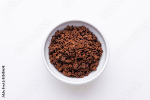Instant granulated coffee from in a coffee cup on white background