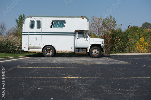 Vintage white and green horse trailer van in parking lot
