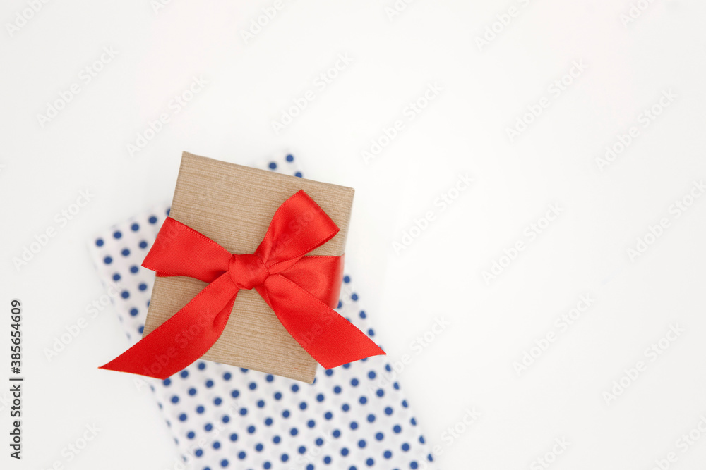 Gift box with red ribbon on white background.