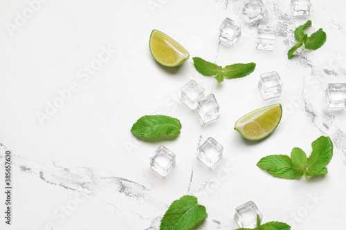 Ice cubes, lime and mint on light background