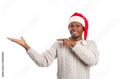African-American man in Santa hat pointing at something on white background