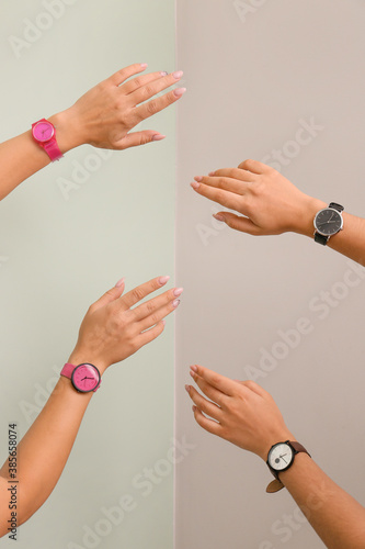 Female hands with watches on color background