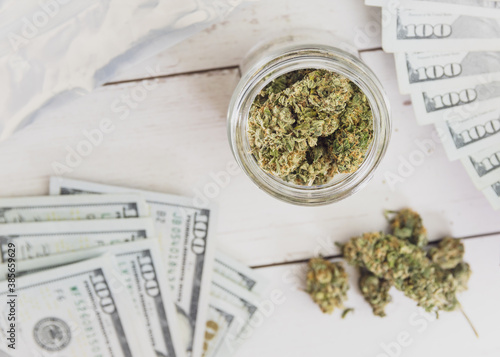 dispensary cannabis flower with  100 dollar bills on table