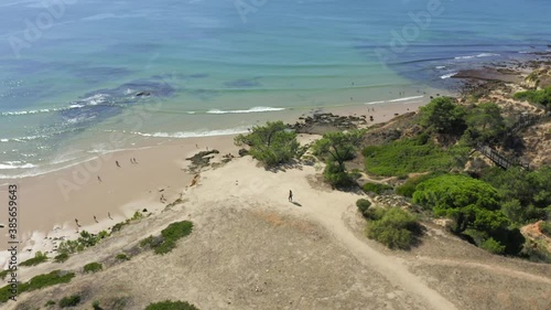 lone person walk out on overhang looking out over the ocean and beach bellow. Warm summersday in paradise photo