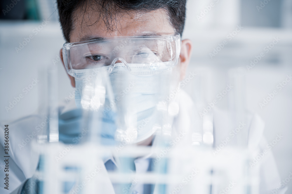 Asian male scientist working in a laboratory. Vaccine development concept. Asian male scientist working in a laboratory. Vaccine development concept.