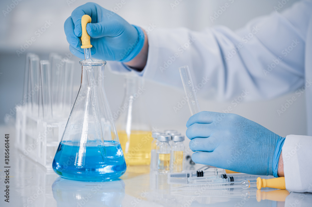 Hand of a scientist working in the laboratory. Vaccine development concept. Hand of a scientist working in the laboratory. Vaccine development concept.