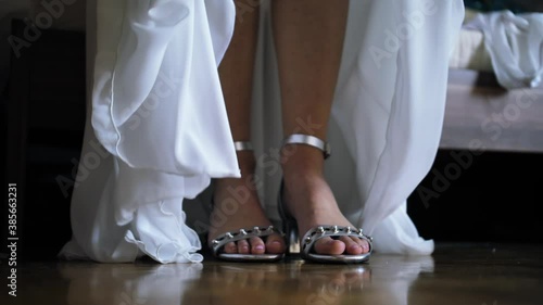 Bride throws wedding dress over wedding shoes and walks away in slowmotion photo