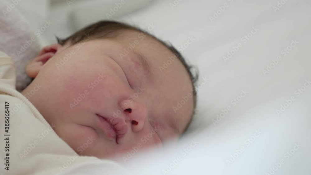 A newborn Asian baby girl asleep after delivery. A newborn Asian baby girl asleep after delivery.