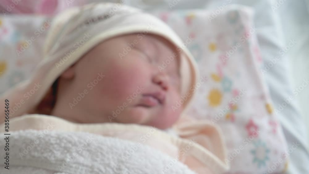 A handheld dolly back shot losing focus as we pull back on a sleeping newborn baby. A handheld dolly back shot losing focus as we pull back on a sleeping newborn baby.