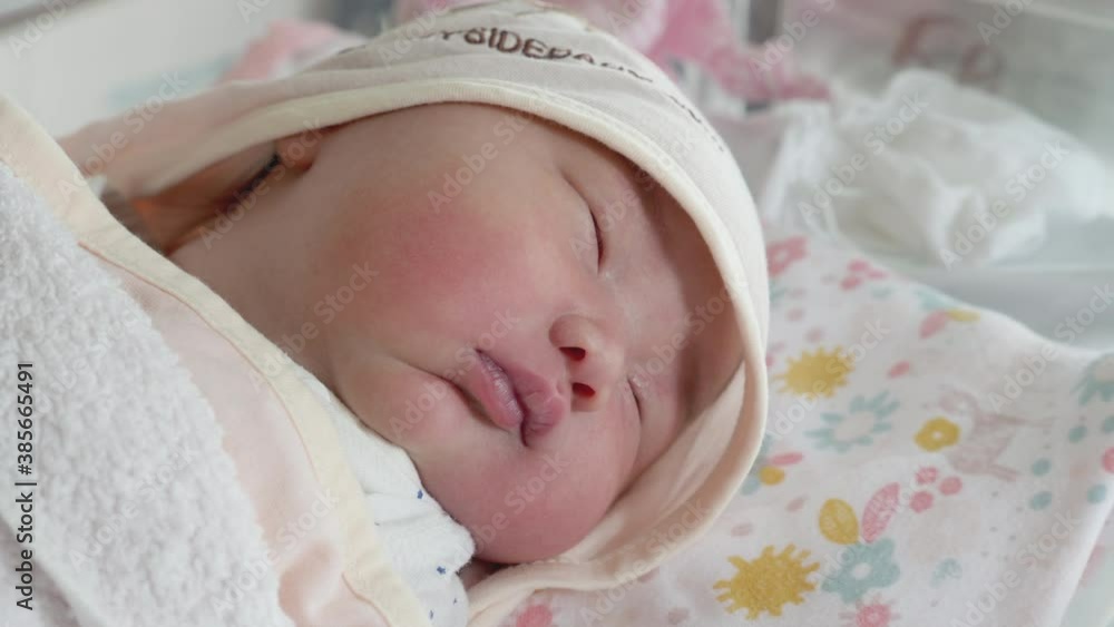 A handheld shot moving backwards to reveal a baby sleeping in the maternity ward. A handheld shot moving backwards to reveal a baby sleeping in the maternity ward.