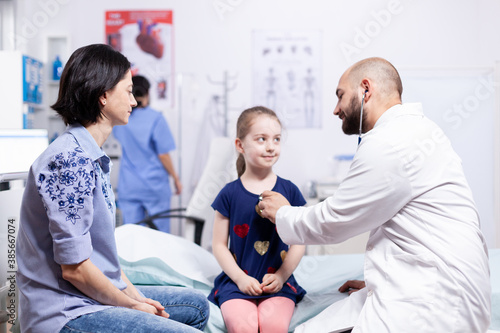Pediatrician checking health of child using stethoscope in hospital office during consultation. Healthcare physician specialist in medicine providing health care services treatment examination.