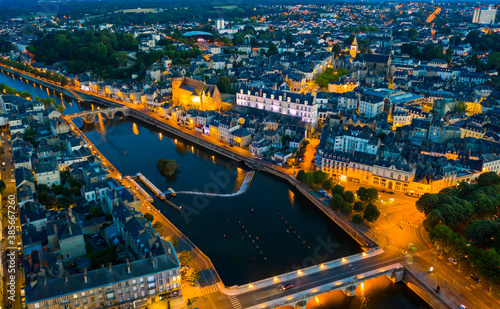 Evening aerial view of Laval with buildings, river Mayenne and old bridge, Mayenne department, north-western France © JackF