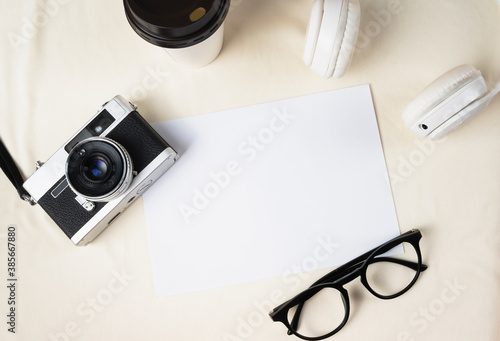 Flat lay - Paper for mock up with vintage film camera and eyeglasses.