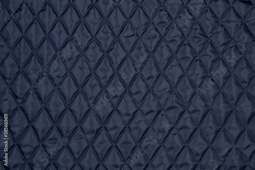 Blue quilted fabric. The texture of the blanket. 