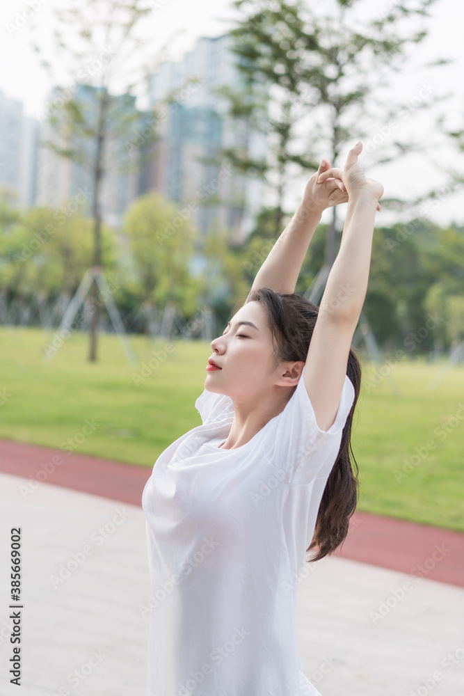 Young long-haired woman is doing exercises in the park Young long-haired woman is doing exercises in the park