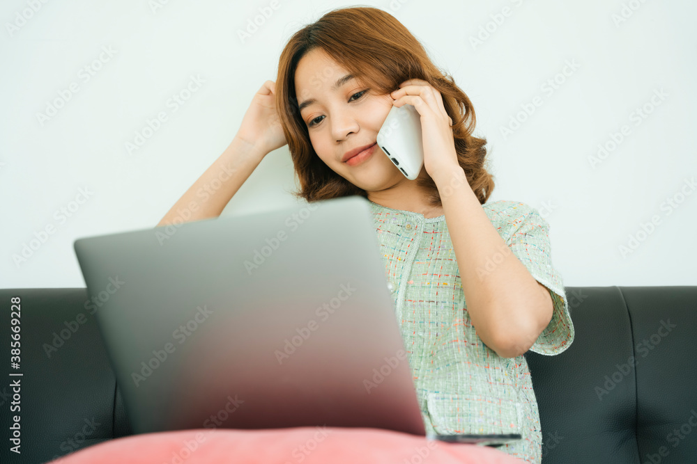 Woman talking on smartphone and working with laptop at home. Woman talking on smartphone and working with laptop at home.