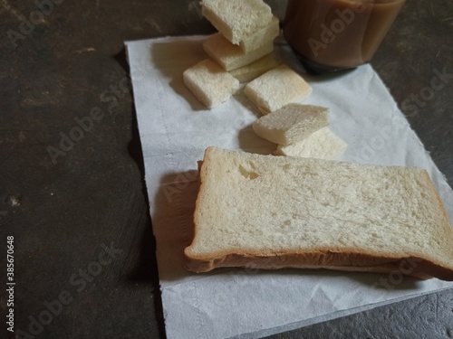 A cup of milk coffee, white bread slices, isolated against the background of the floor.