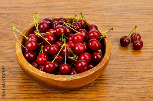 Wooden bowl with ripe sweet garden cherry