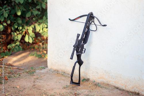 Photo A black crossbow stands near the wall in the courtyard