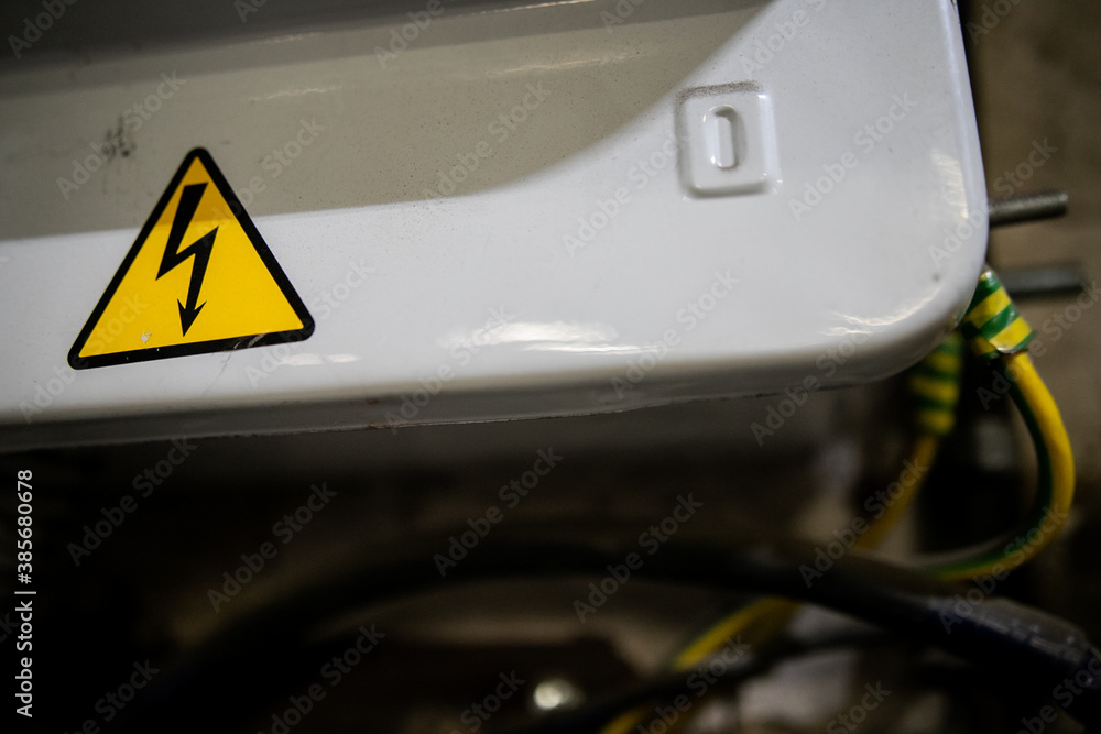 Obraz premium Yellow sigh danger electric shock with lightning in triangle on a metal electric distribution box.