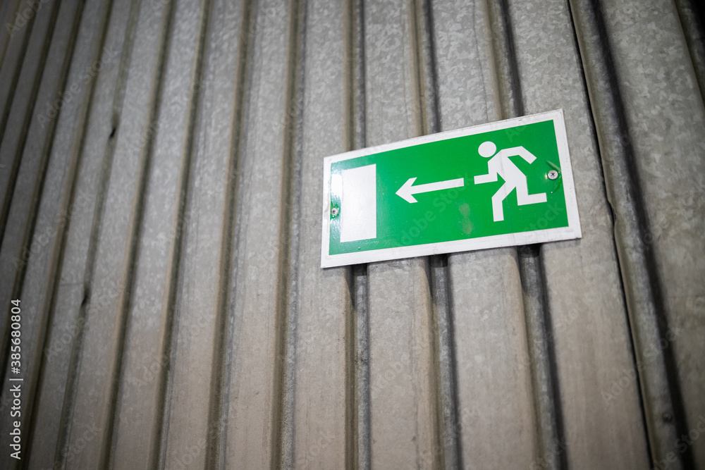 Emergency exit sign, escape sign on the wall. Safety sign in office company for exit building. Emergency exit sign, escape sign on the wall. Safety sign in office company for exit building.