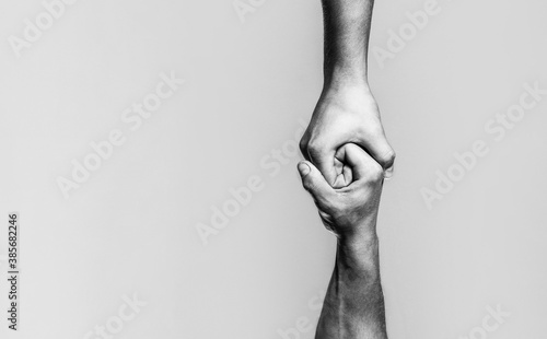 Two hands, helping arm of a friend, teamwork. Helping hand concept and international day of peace, support. Black and white photo
