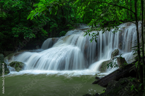 A beautiful waterfall deep in the tropical forest, steep mountain adventure in the rainforest. © tomruethai