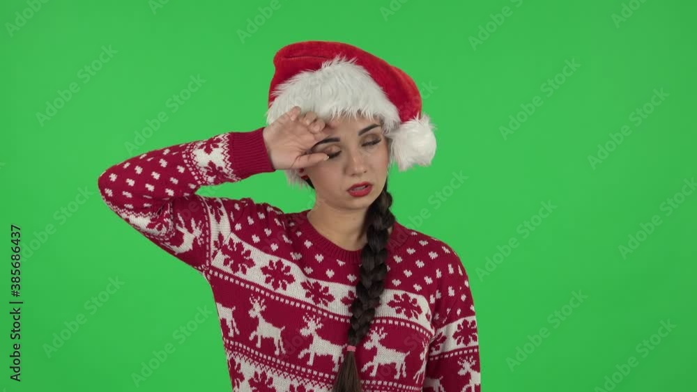 Portrait of sweety girl in Santa Claus hat is upset and tired. Green screen Portrait of sweety girl in Santa Claus hat is upset and tired. Green screen